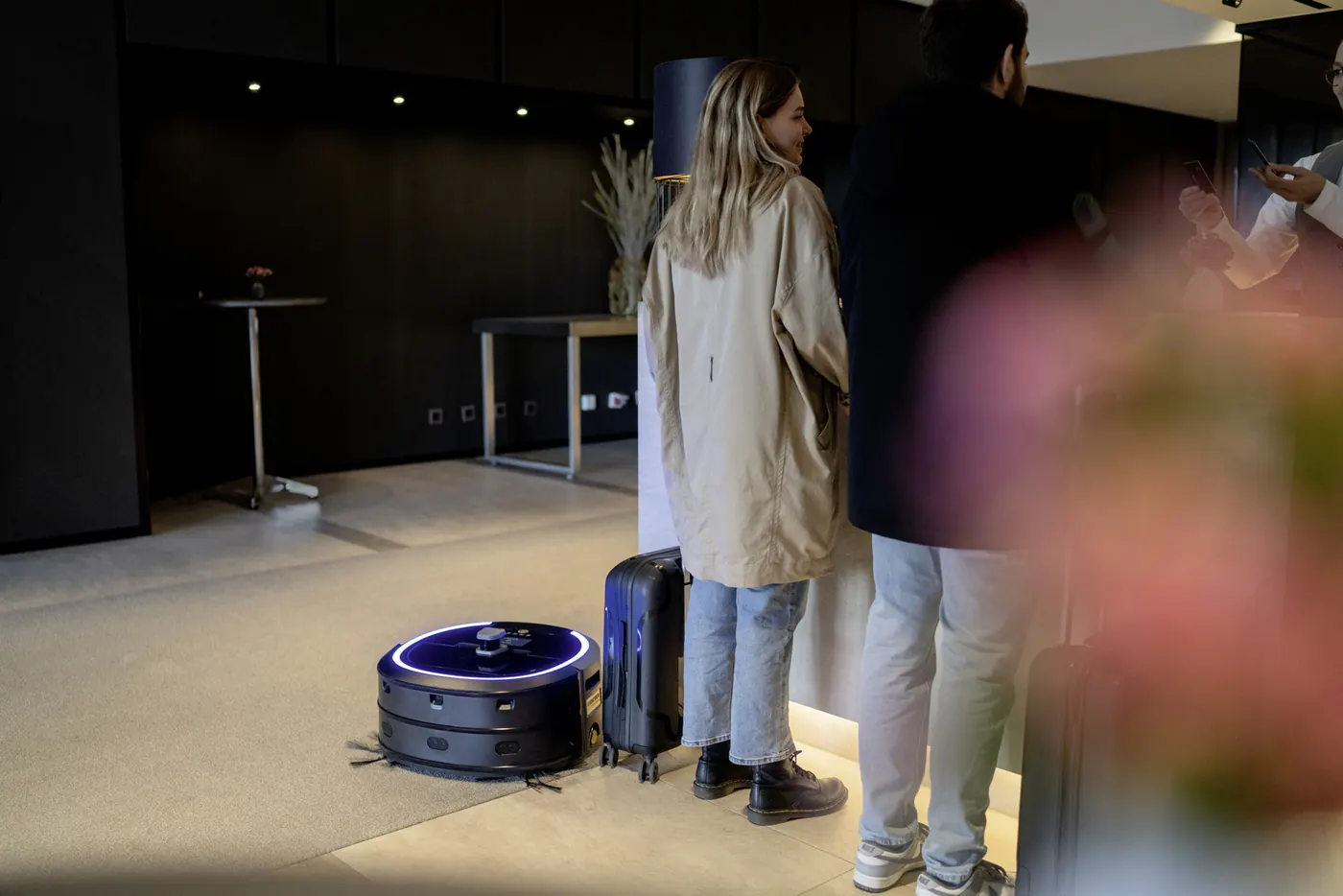 Kärcher KIRA CV 50 : Hall d'hôtel avec clients et bagages, robot en action au sol (1600×1067)